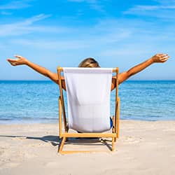A person relaxing in a chair on a sunny beach.